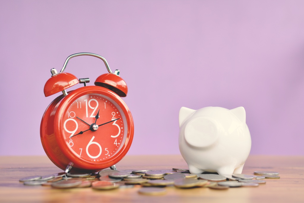 piggy-bank-alarm-clock-with-coins-against-pink-wall-table.jpg копилка